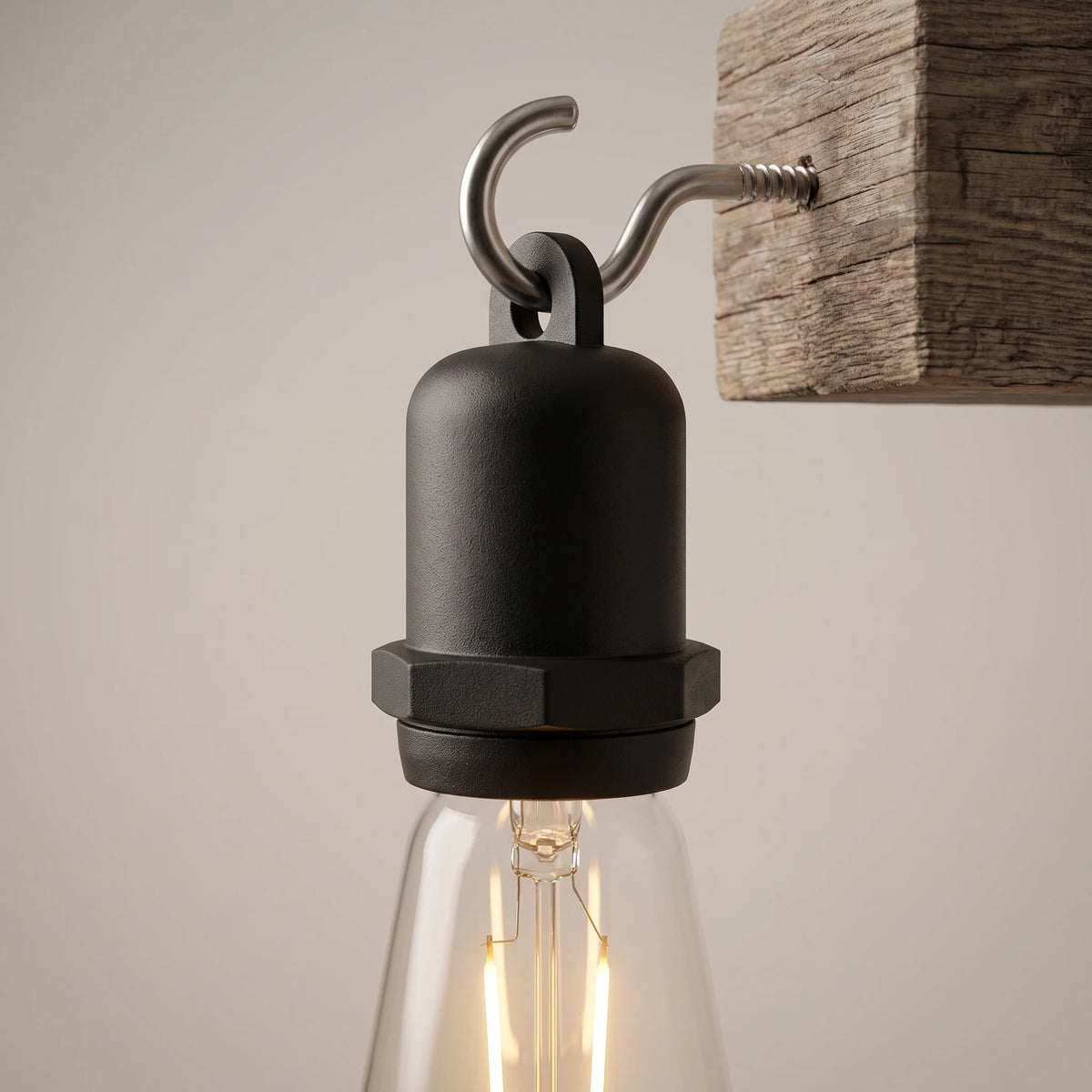 The socket's hanging loop hooked onto a screw-in hook fixed into a weathered wooden beam