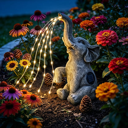 Solar elephant garden light glowing at dusk in a flowerbed