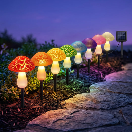 Solar mushroom lights glowing along a garden bed at dusk