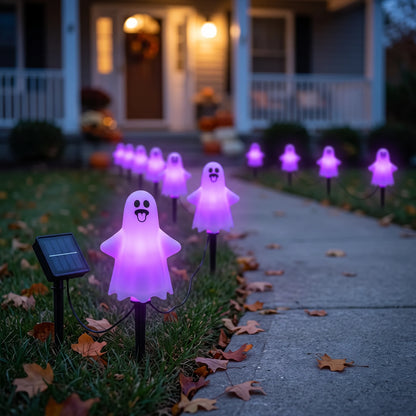 Ghost stake lights glowing purple along a front lawn path at dusk, with the solar panel staked in the grass