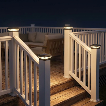 Solar post cap lights on white deck railing posts and stairs at night
