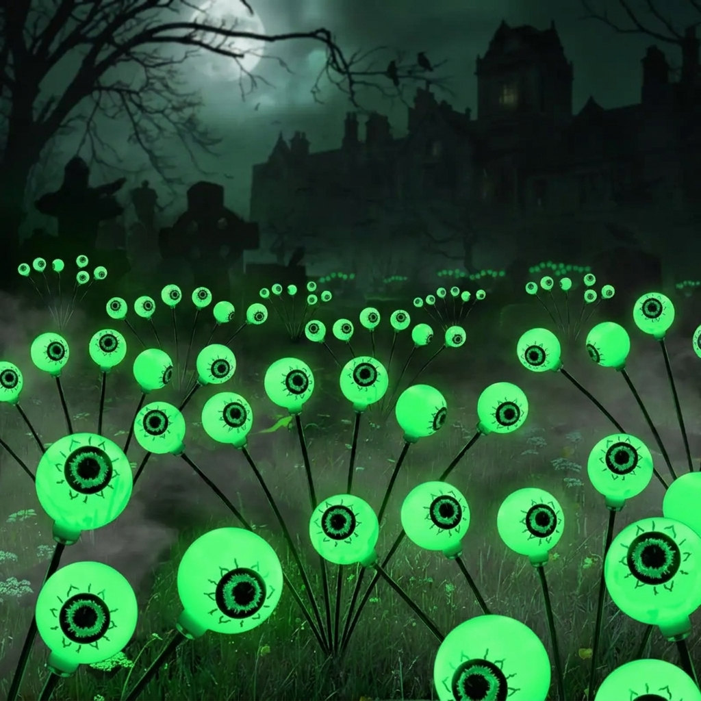 Solar Halloween eyeball light stakes glowing green in a yard