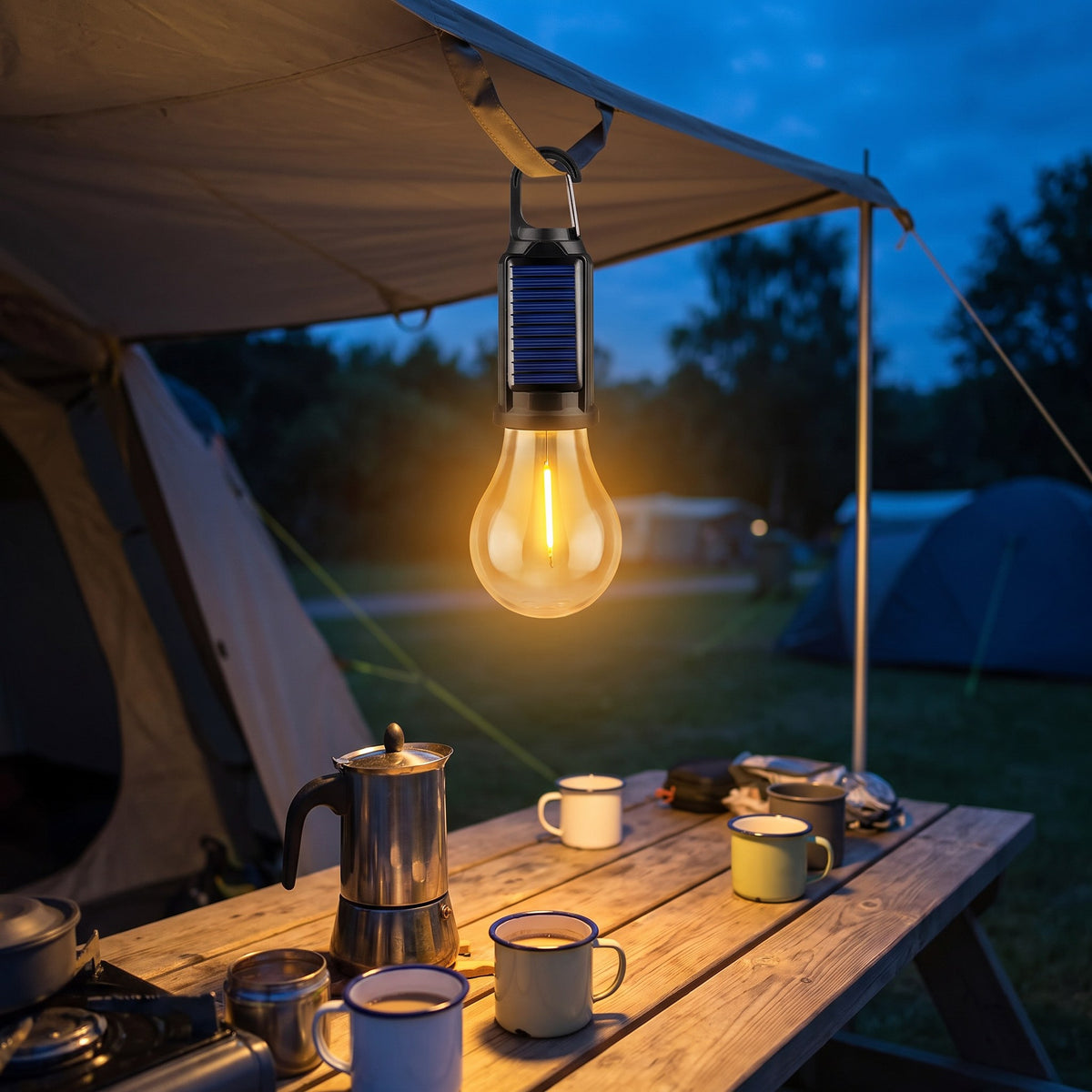 Solar camping bulb light hanging over a camp table with a coffee pot and enamel mugs at blue hour