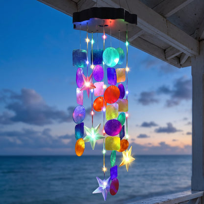 Solar seashell chime glowing at dusk on a coastal porch