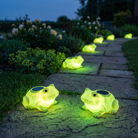 Solyra solar frog path lights glowing along a garden path at dusk