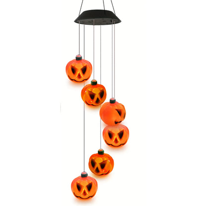 Solar pumpkin wind chime with six glossy jack-o'-lantern lights hanging in a spiral from a black solar cap, on a white background