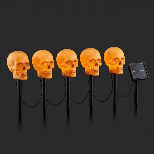 Set of five skull stake lights wired to a single solar panel, shown lit against a dark background