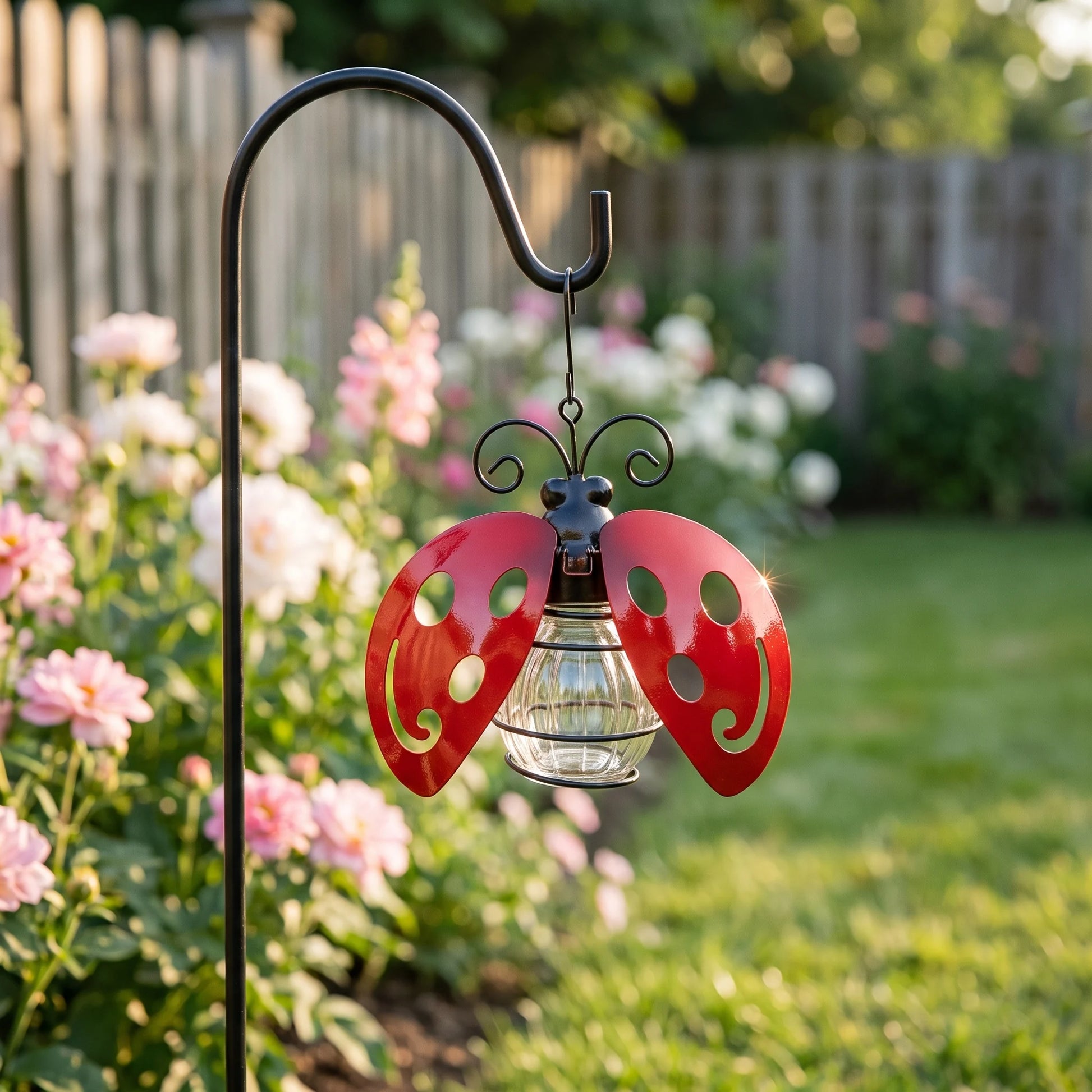 Solar ladybug light hanging in garden planting in daylight
