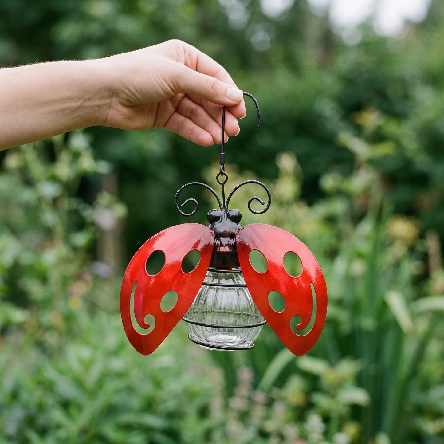 Hand holding the solar ladybug light to show its true size