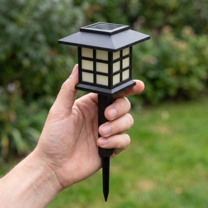 Hand holding one solar lantern path light to show its size, about 12.6 inches tall