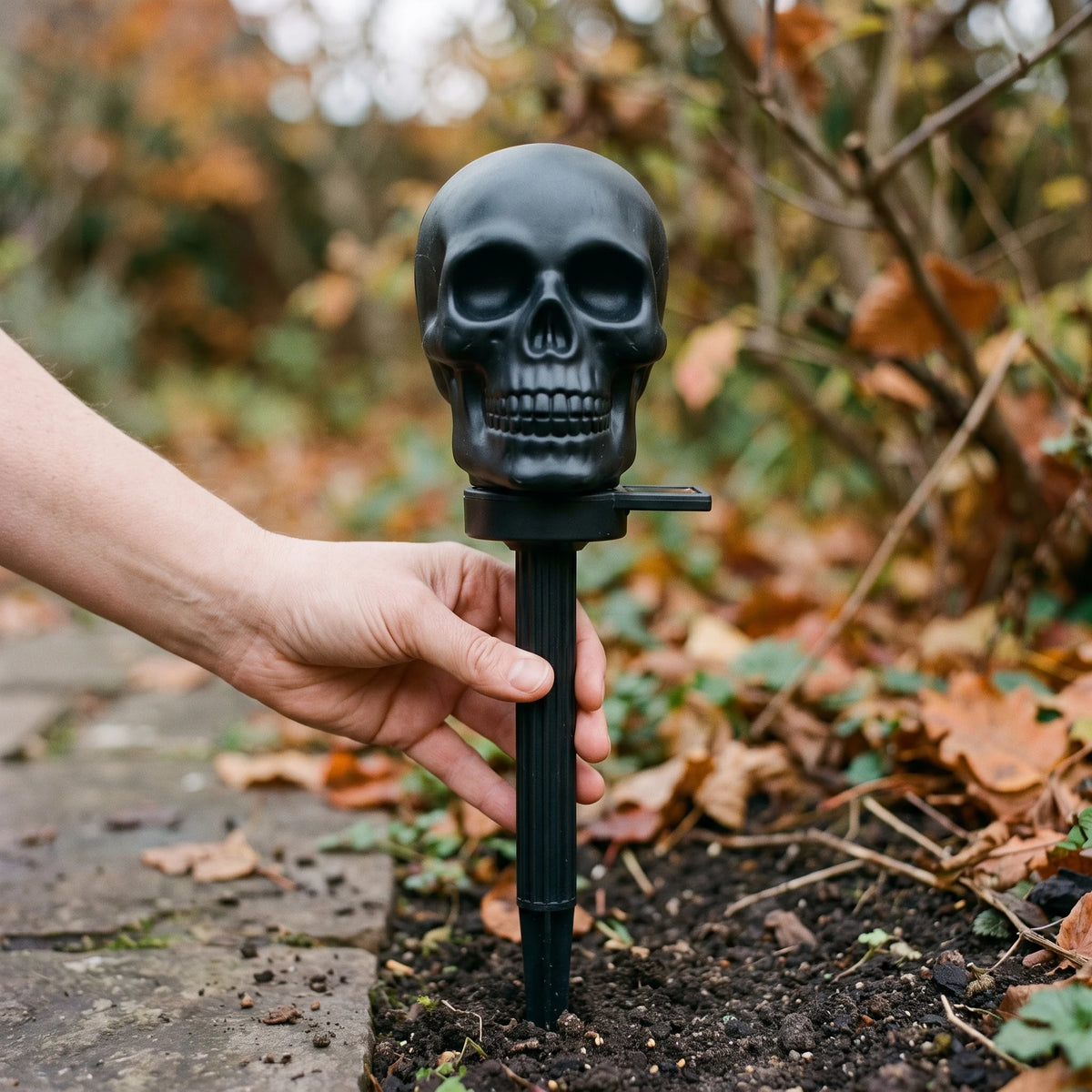 Hand holding the solar skull torch light to show its true size