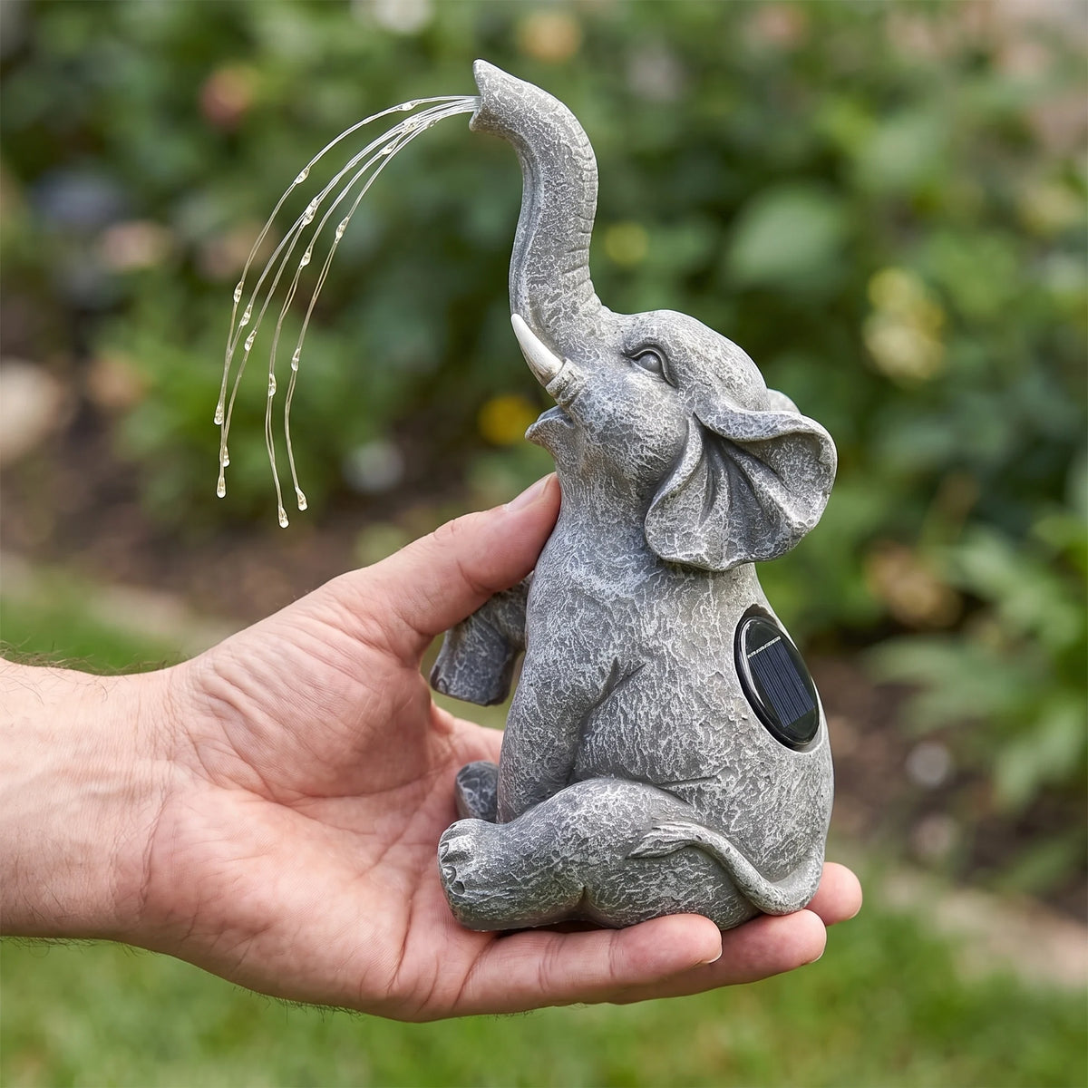 Solar elephant garden light held in one hand for scale