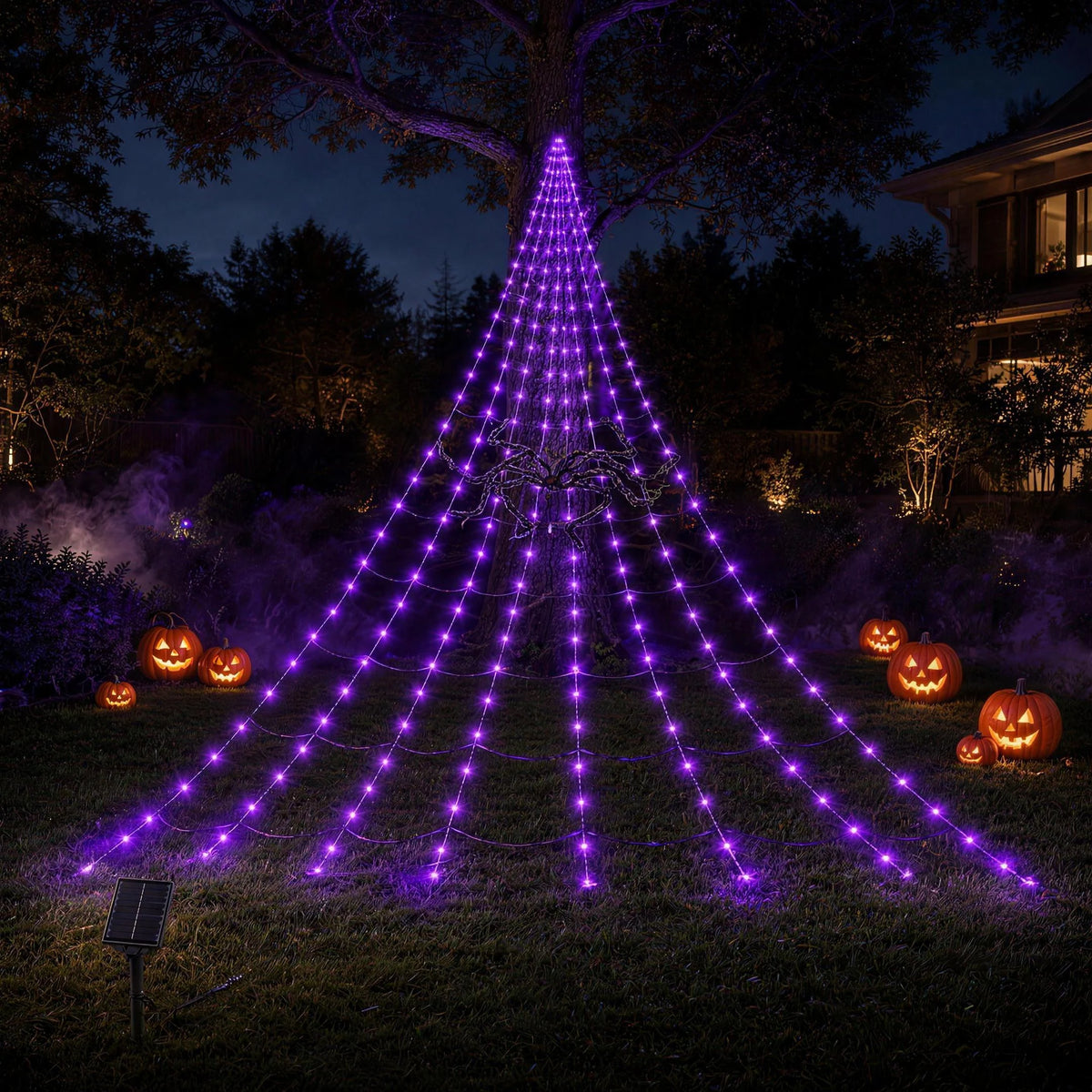 Purple solar spider web light hung from a large tree over a back garden at night