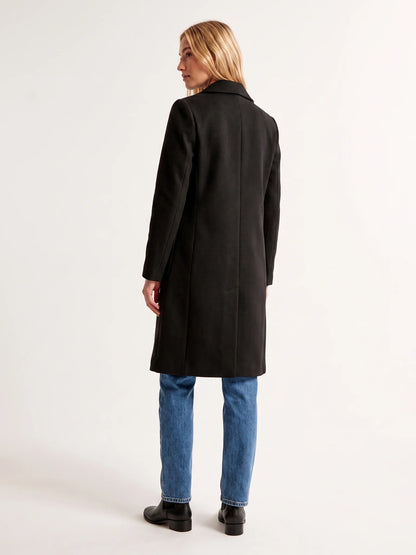 The back of the Black wool-blend coat on a model, showing the shoulder line and the below-the-knee hem