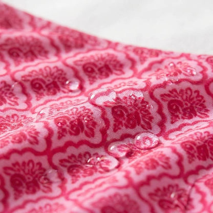 Close-up of the scalloped-print swim fabric with water droplets on the surface