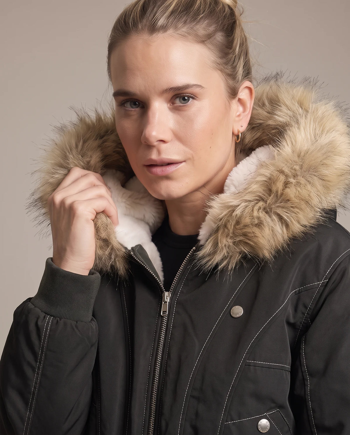 Close view of the black jacket's faux fur hood trim and ivory shearling collar