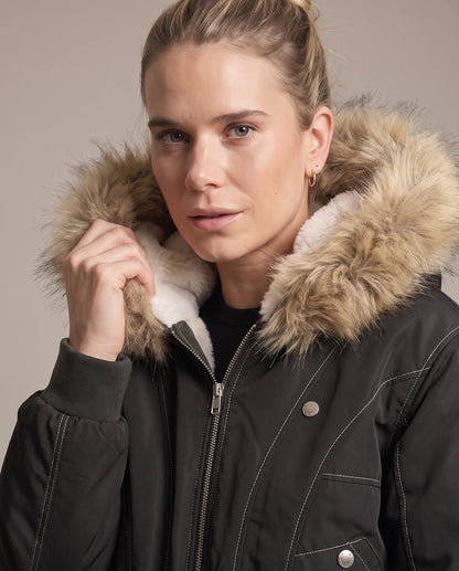 Close view of the black jacket's faux fur hood trim and ivory shearling collar
