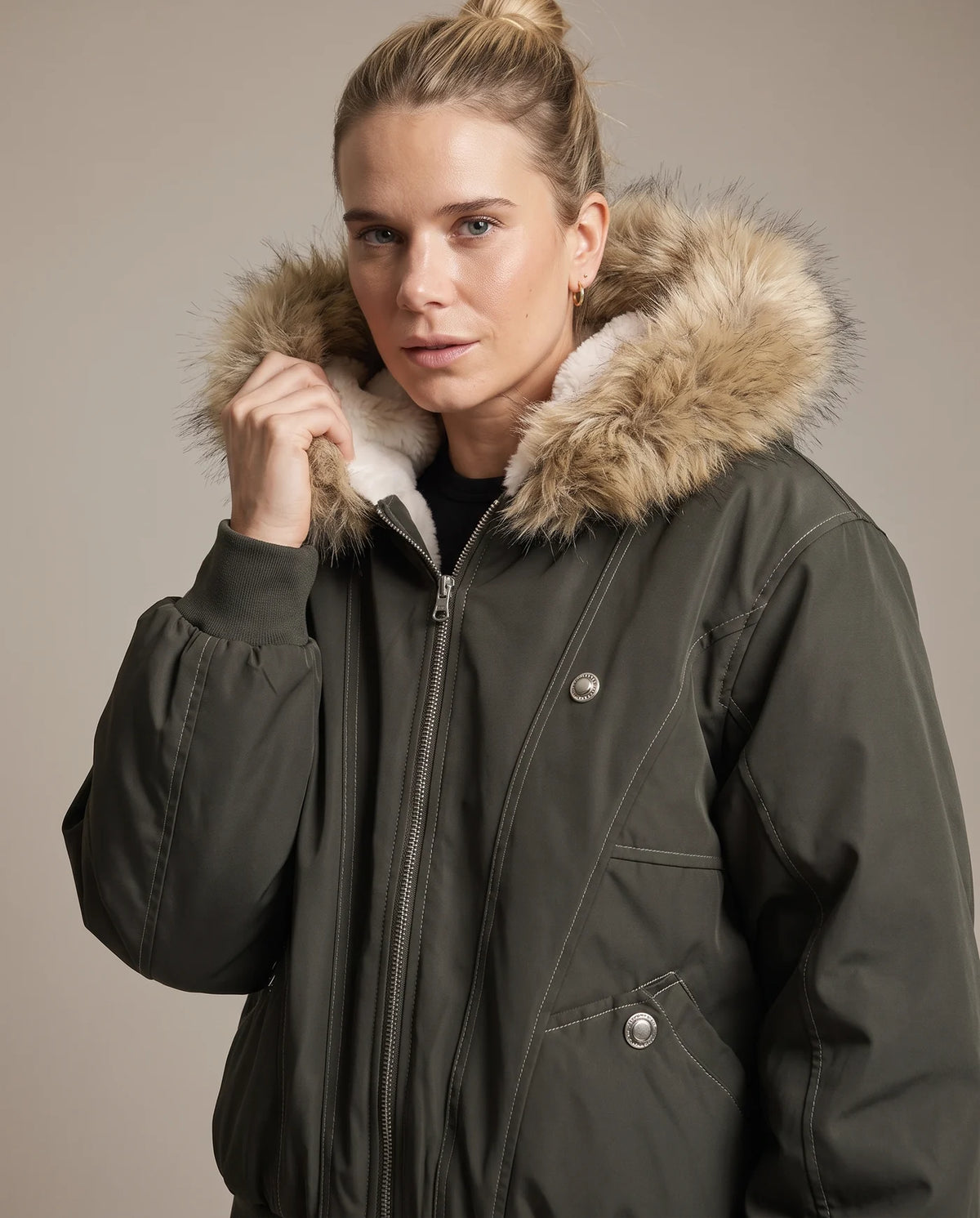 Close view of the army green jacket's faux fur hood trim and ivory shearling collar
