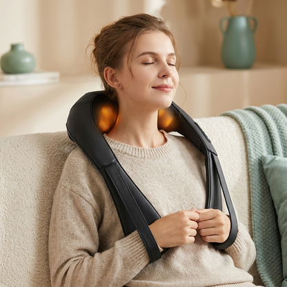 Person relaxing on a sofa wearing the black shiatsu neck and shoulder massager
