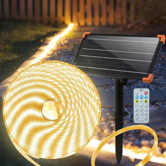 50ft solar LED rope light coiled beside its solar panel stake and remote, lit warm white along a garden path